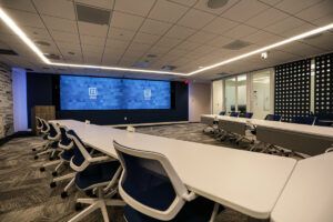 Briar Ridge conference room showing two screens with McCann logos, chairs and tables.