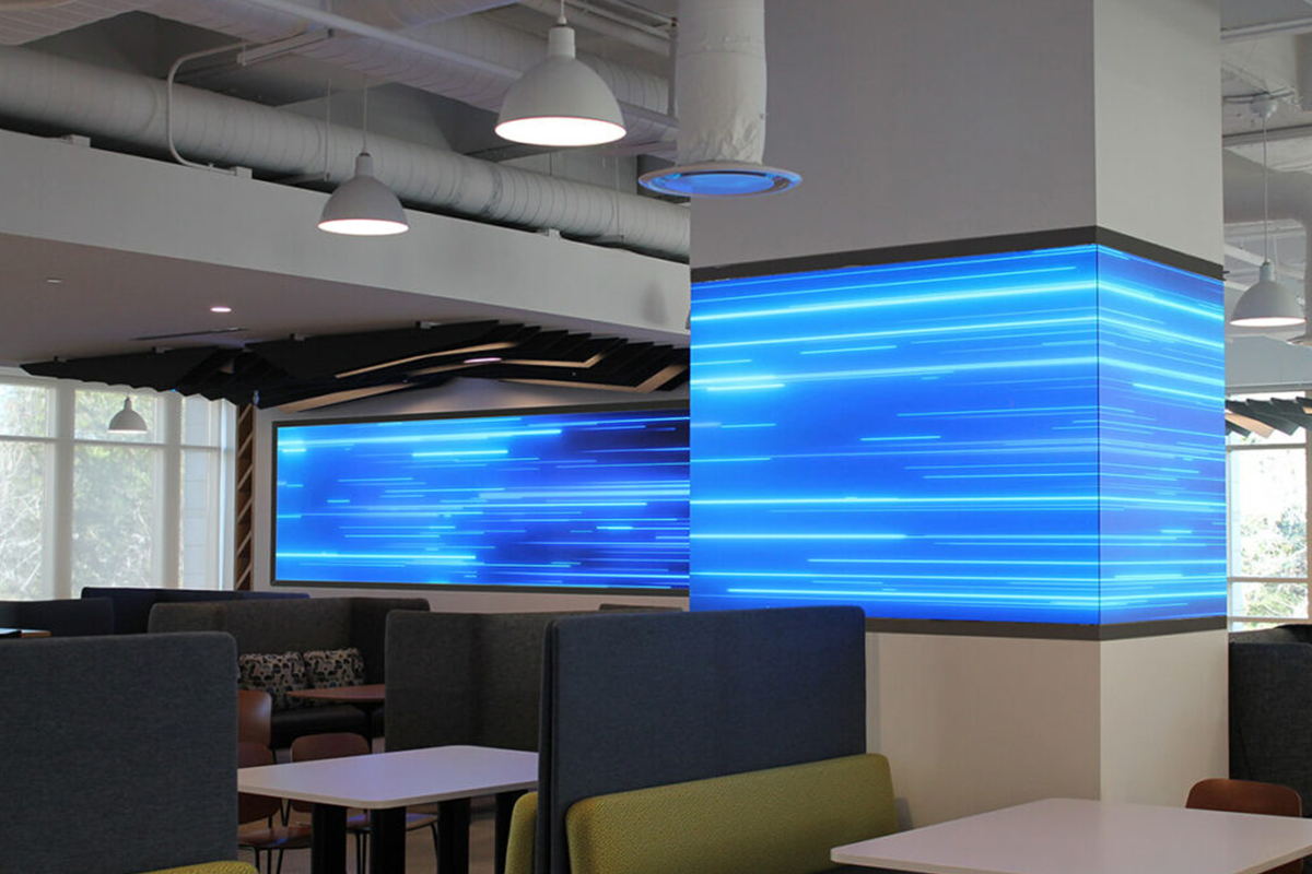 Large video wall and 4-sided video column displaying blue graphics.