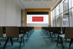 Modern lecture hall at Boston University with jumbo projector screen at the front of the room.