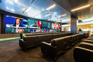 A sportsbook in New Jersey featuring rows of seats and a large, multi-screen AV system display showing various sports channels.