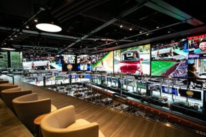 Image of the Draft Kings Sportsbook venue with a large, curved video wall.