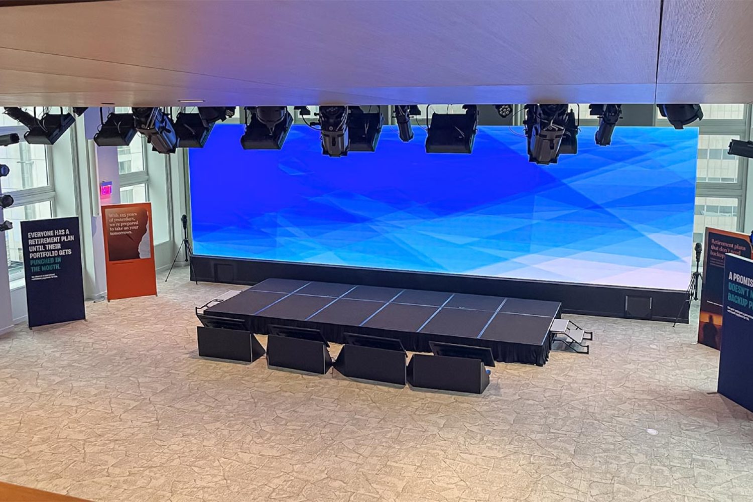 Large LED video wall in a modern auditorium with stage lighting and seating.