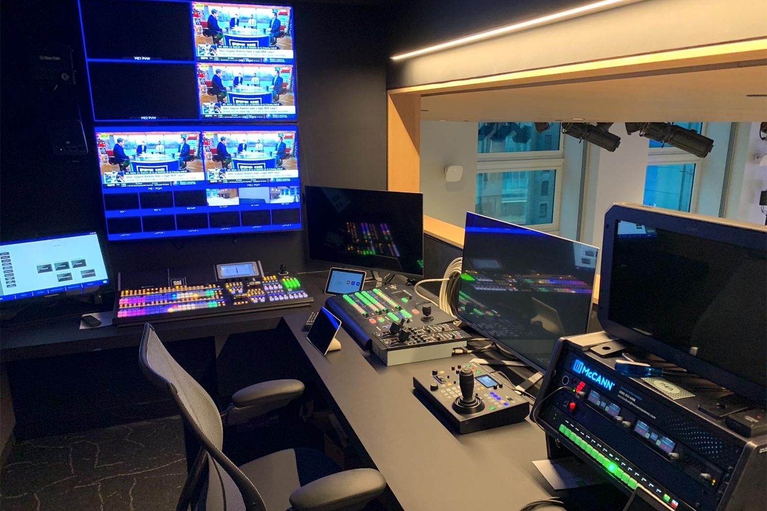 A control room with multiple monitors, switchboards, and high-tech broadcasting equipment.