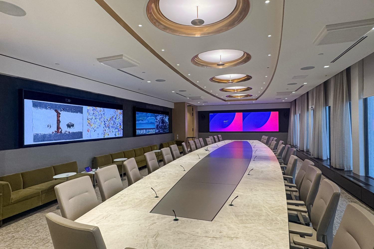 Another angle of the executive boardroom, highlighting the luxurious ceiling design with circular recessed lighting. The room’s setup ensures clear sightlines to the screens, maximizing engagement during meetings.