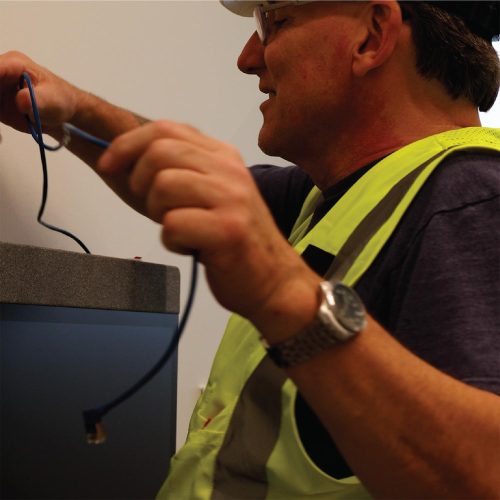 Technician holding Ethernet cable preparing to plug into device