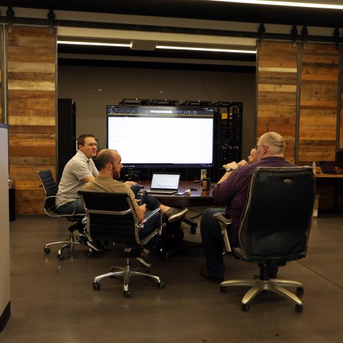 Group of men seated around a conference table discussing a project