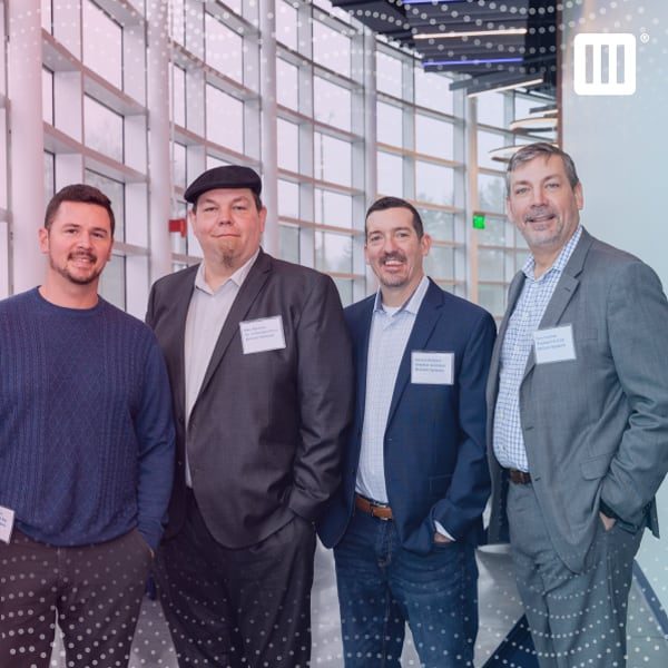 Four members of the McCann team smiling and standing in the hallway.