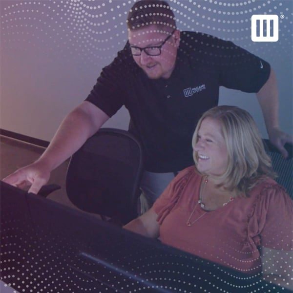 Man and woman working together while looking at a computer screen.