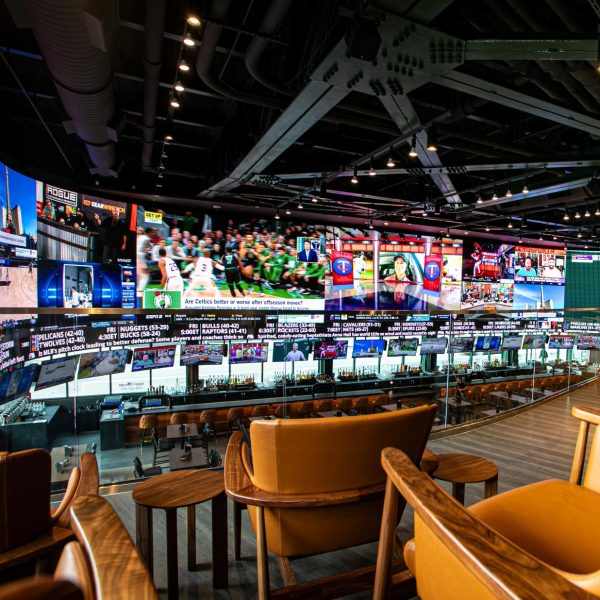 A large indoor sports bar with multiple screens displaying various sports content.