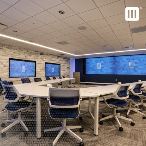 Modern conference room setup with two flatscreen displays on one wall and a full video wall on the other.
