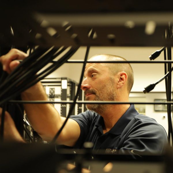 cta-create Technician working with cables inside a network rack