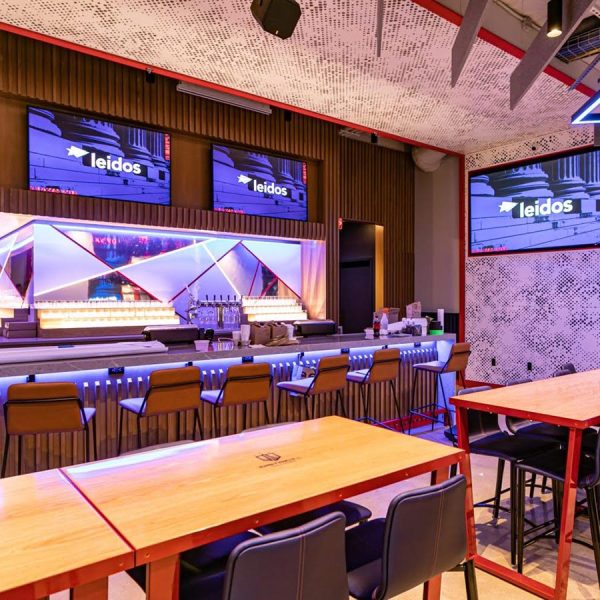 cta-hospitality-002 Stylish bar and lounge with modern lighting, digital displays, and Leidos branding