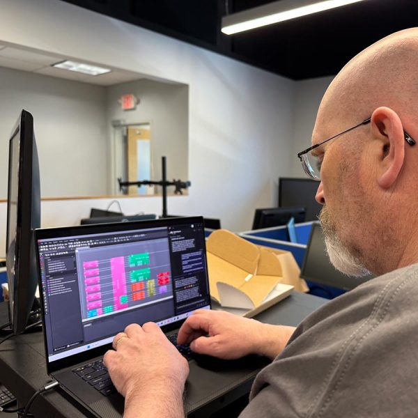 cta-markets Man working on a laptop running AV system software in a modern office