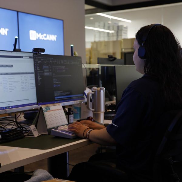 cta-retail Woman wearing a headset working on dual monitors at a modern workstation