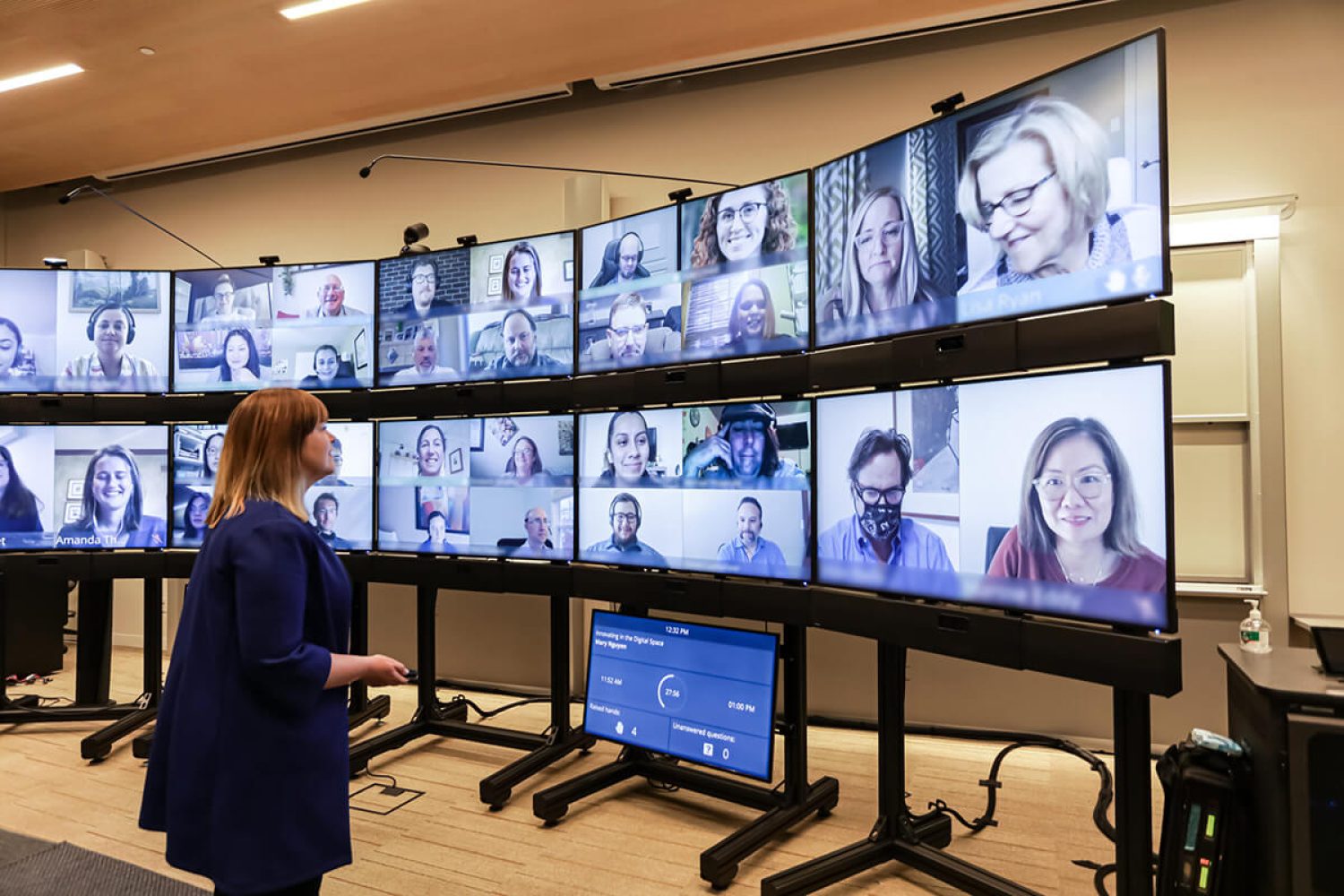 Semi circle of video screens with a professor conducting a remote lecture at the University of California Berkeley.